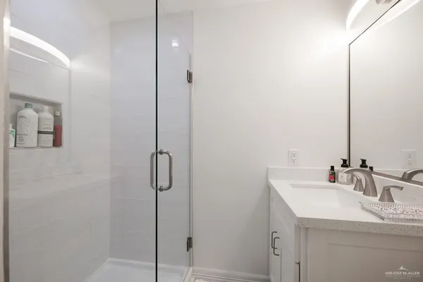 a bathroom with a shower sink and mirror