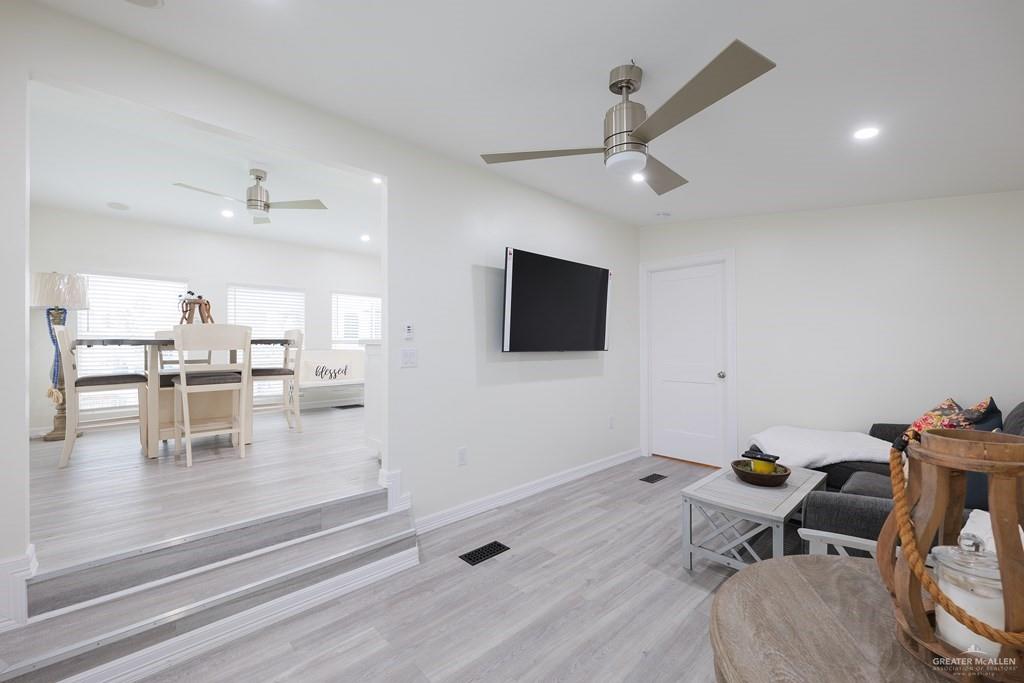 87 Abalone Circle Port Isabel, TX 78578 - Photo 2 of 40 a kitchen with stainless steel appliances kitchen island granite countertop a sink and white cabinets with wooden floor