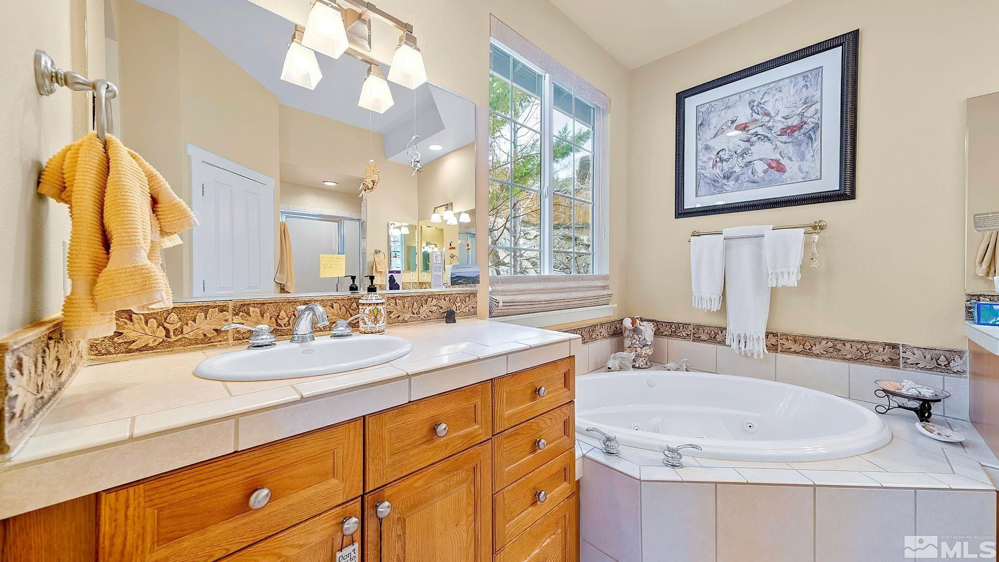 4940 Turning Leaf Way Reno, NV 89519 - Photo 23 of 34 a bathroom with a double vanity sink and a mirror