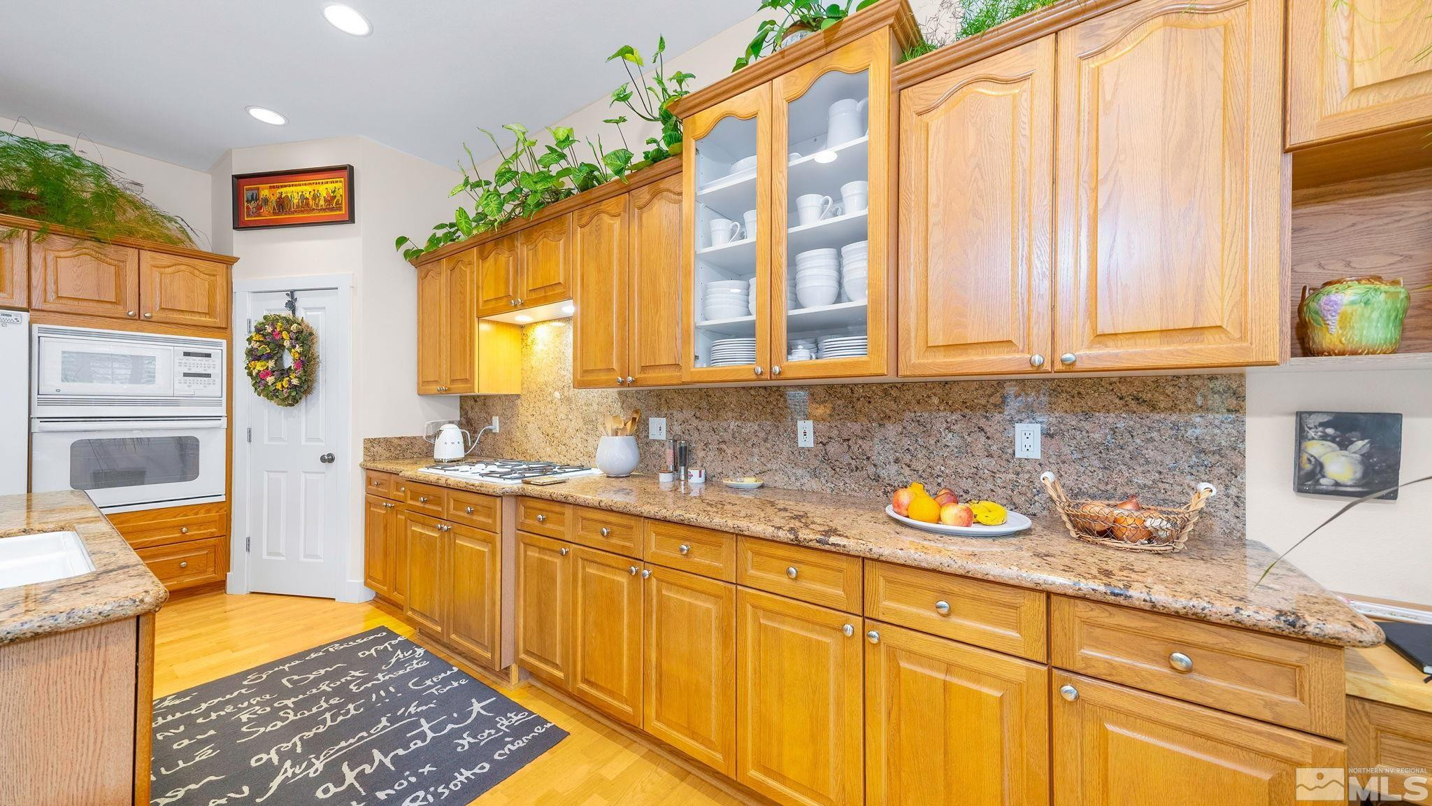 4940 Turning Leaf Way Reno, NV 89519 - Photo 5 of 34 a kitchen with stainless steel appliances granite countertop a sink a stove and a window