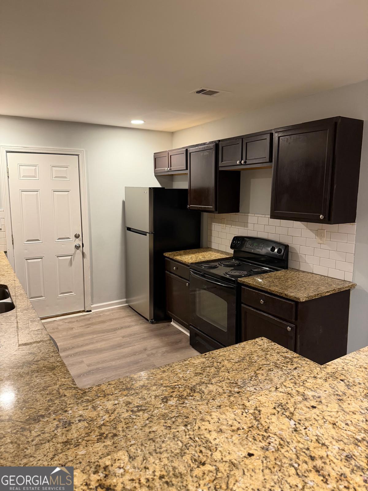 3456 Thompson Drive Northwest Atlanta, GA 30331 - Photo 4 of 18 a kitchen with a refrigerator and a stove top oven