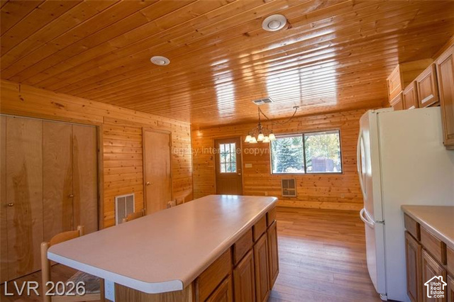1129 Ponderosa Road, Unit 40 Hatch, UT 84735 - Photo 11 of 47 Wood-paneled walls and ceiling, recessed lighting, central kitchen island with light-colored countertop, wood-finish flooring, and built-in cabinetry