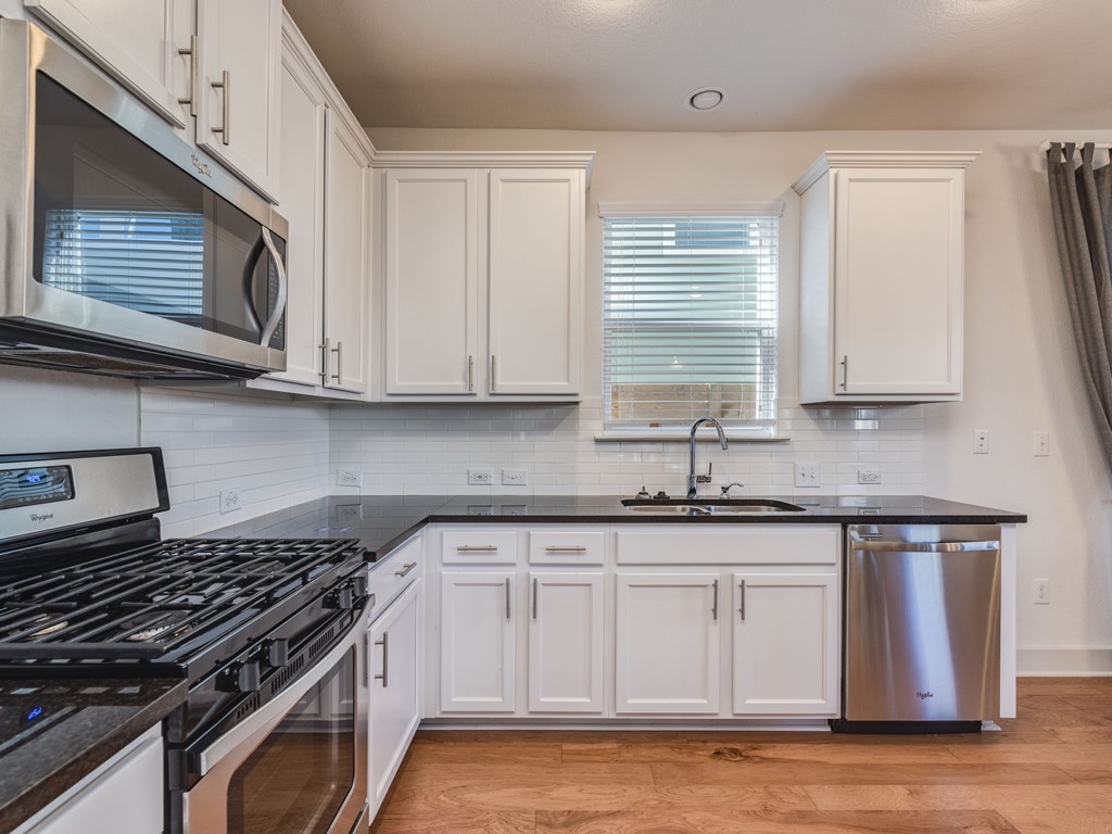 2208 Capulet Street Austin, TX 78741 - Photo 8 of 23 a kitchen with granite countertop a sink a stove and cabinets