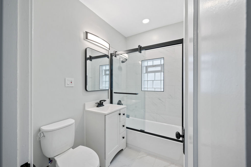 5230 West Deming Place Chicago, IL 60639 - Photo 15 of 45 a bathroom with a toilet sink and mirror