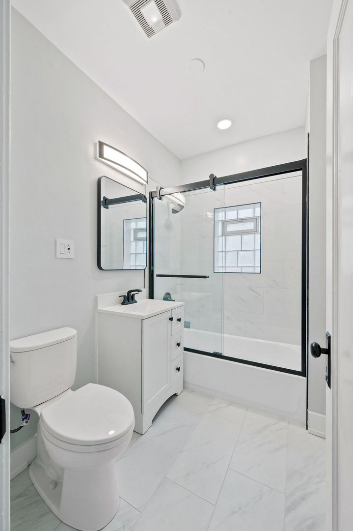 5230 West Deming Place Chicago, IL 60639 - Photo 16 of 45 a bathroom with a toilet sink and mirror