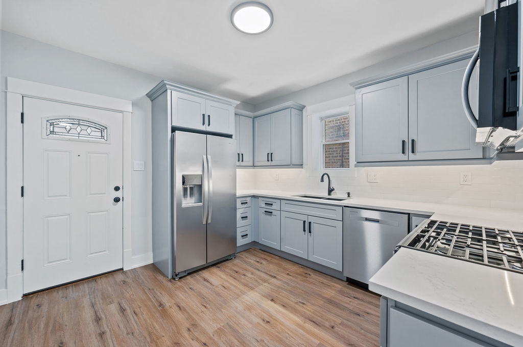 5230 West Deming Place Chicago, IL 60639 - Photo 20 of 45 a kitchen with granite countertop a sink cabinets and stainless steel appliances