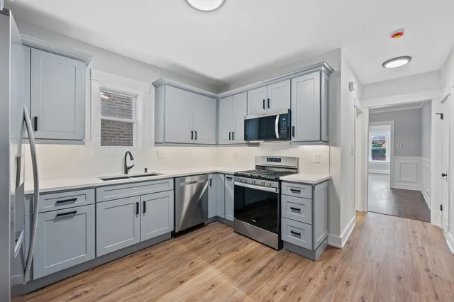 a kitchen with stainless steel appliances granite countertop a stove a sink and a refrigerator