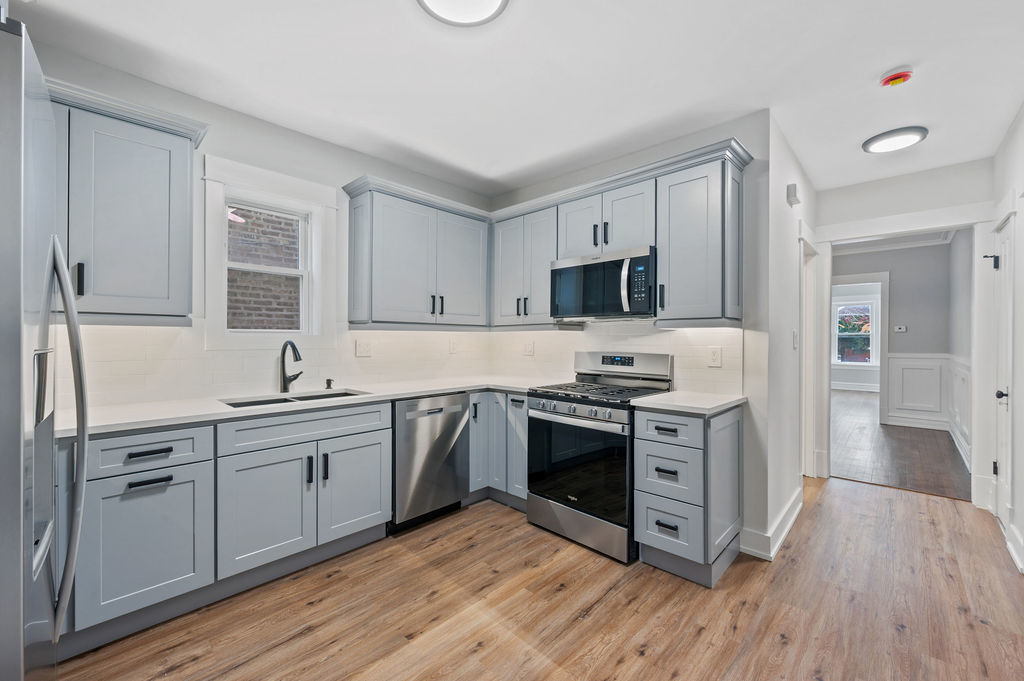 5230 West Deming Place Chicago, IL 60639 - Photo 21 of 45 a kitchen with stainless steel appliances granite countertop a stove a sink and a refrigerator