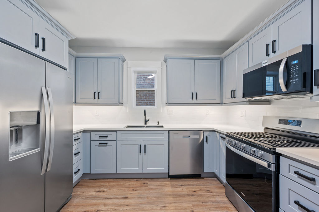 5230 West Deming Place Chicago, IL 60639 - Photo 22 of 45 a kitchen with stainless steel appliances granite countertop a stove top oven a sink dishwasher a refrigerator and cabinets with wooden floor
