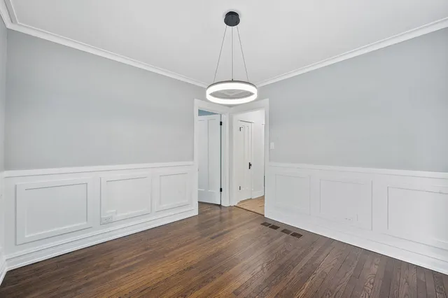 a view of a room with wooden floor and white walls