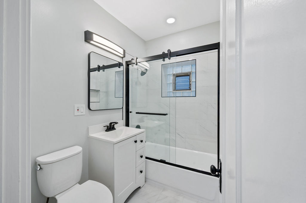 5230 West Deming Place Chicago, IL 60639 - Photo 33 of 45 a bathroom with a shower sink mirror and toilet