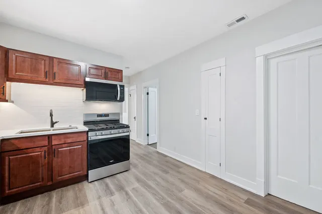 a kitchen with stainless steel appliances granite countertop a stove a sink and a refrigerator