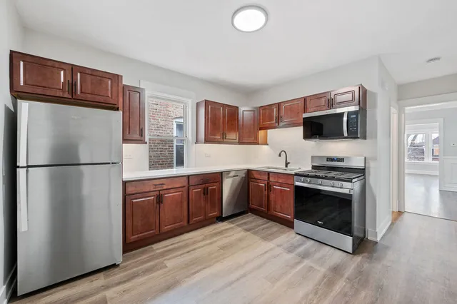 a kitchen with stainless steel appliances granite countertop a refrigerator stove and sink