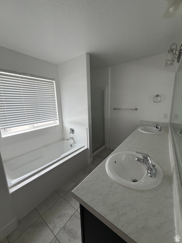 878 West Mckenna Road Bluffdale, UT 84065 - Photo 7 of 11 Dual vanity with integrated sinks, a white soaking tub, a separate glass-enclosed shower, and tile flooring