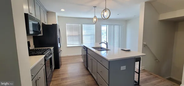 a kitchen with stainless steel appliances granite countertop a refrigerator a stove and a sink