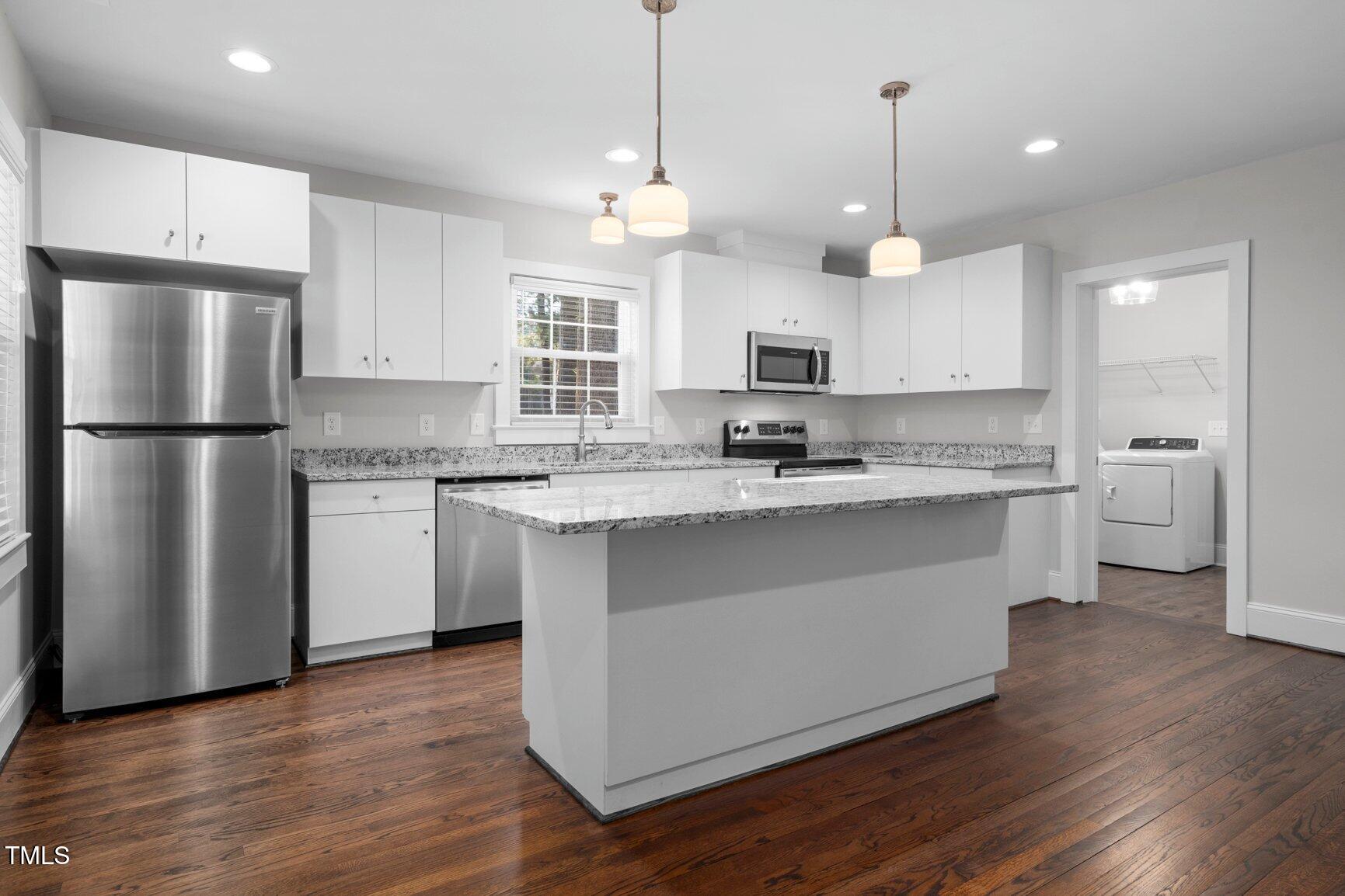 419 West Burnette Avenue Enfield, NC 27823 - Photo 9 of 23 a kitchen with kitchen island granite countertop a sink a center island a refrigerator and a window
