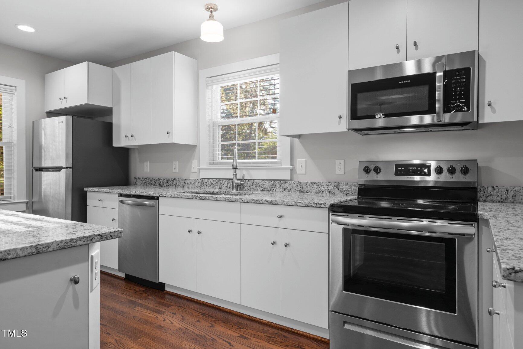 419 West Burnette Avenue Enfield, NC 27823 - Photo 10 of 23 a kitchen with stainless steel appliances granite countertop a sink dishwasher a stove and a microwave oven with cabinets