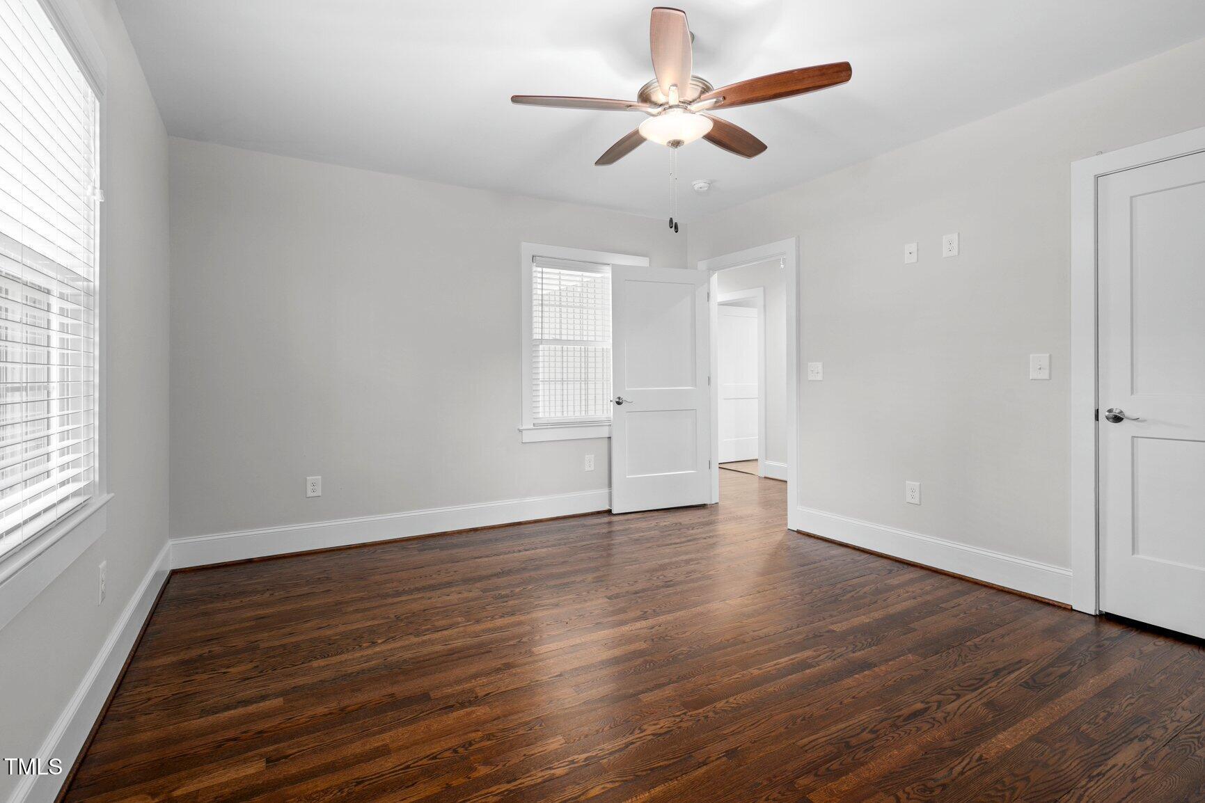 419 West Burnette Avenue Enfield, NC 27823 - Photo 12 of 23 an empty room with wooden floor ceiling fan and window