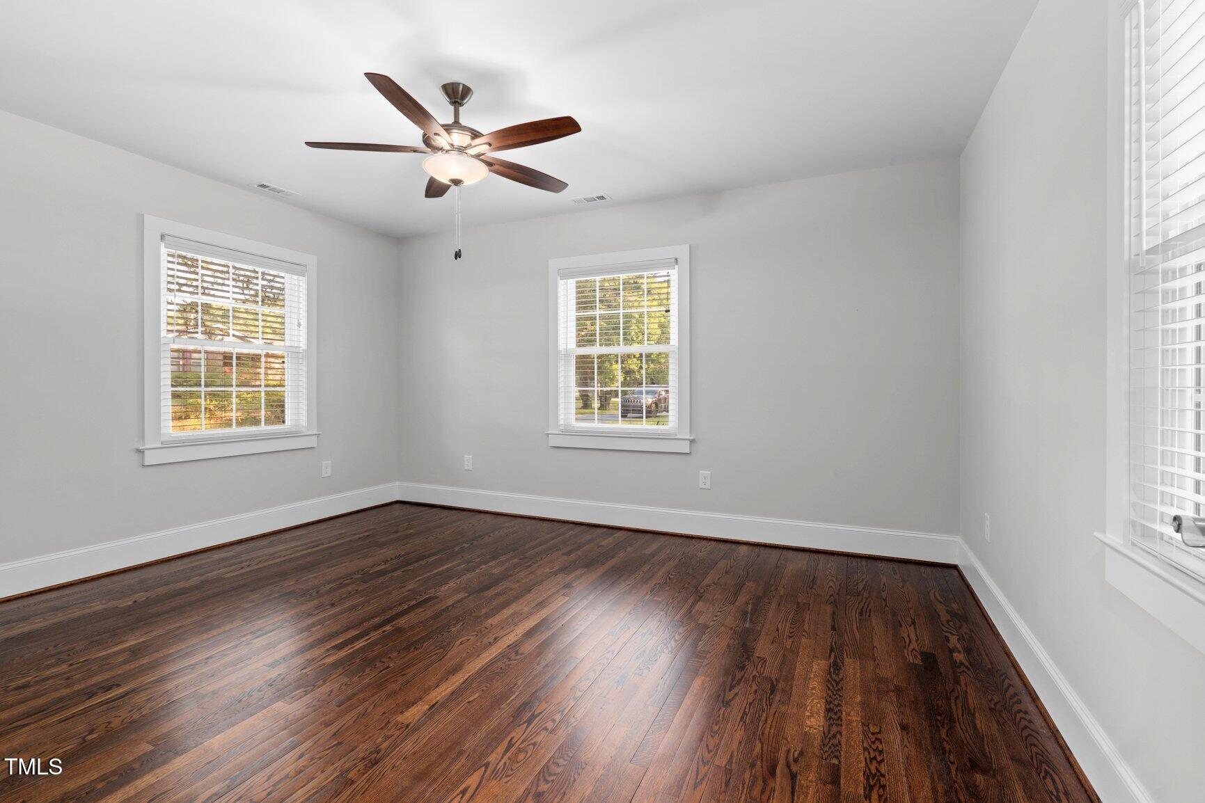 419 West Burnette Avenue Enfield, NC 27823 - Photo 13 of 23 an empty room with wooden floor windows and fan