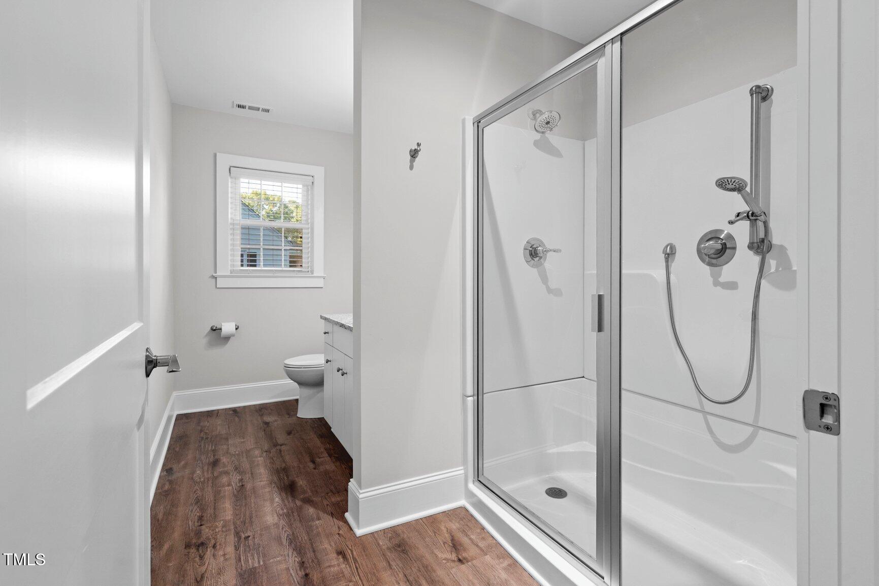 419 West Burnette Avenue Enfield, NC 27823 - Photo 15 of 23 a bathroom with a glass shower door and a window