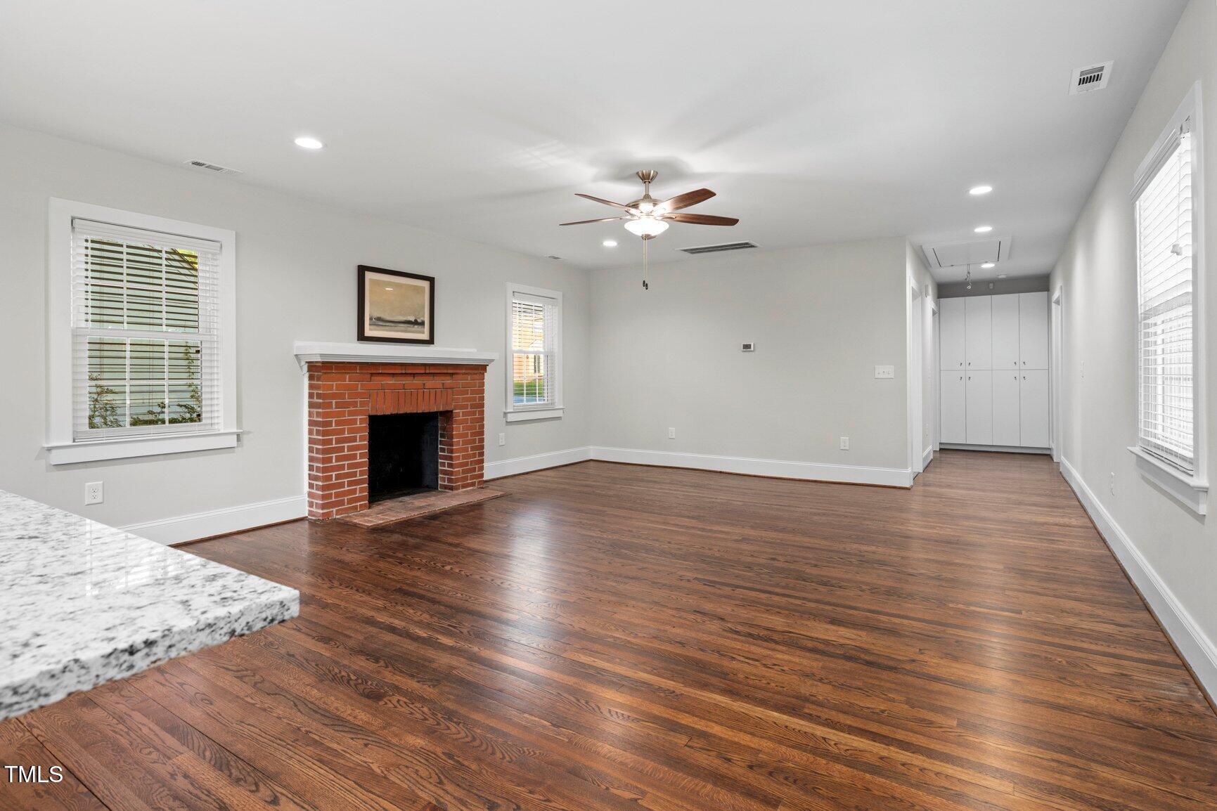 419 West Burnette Avenue Enfield, NC 27823 - Photo 5 of 23 a view of a livingroom with a fireplace a ceiling fan and windows