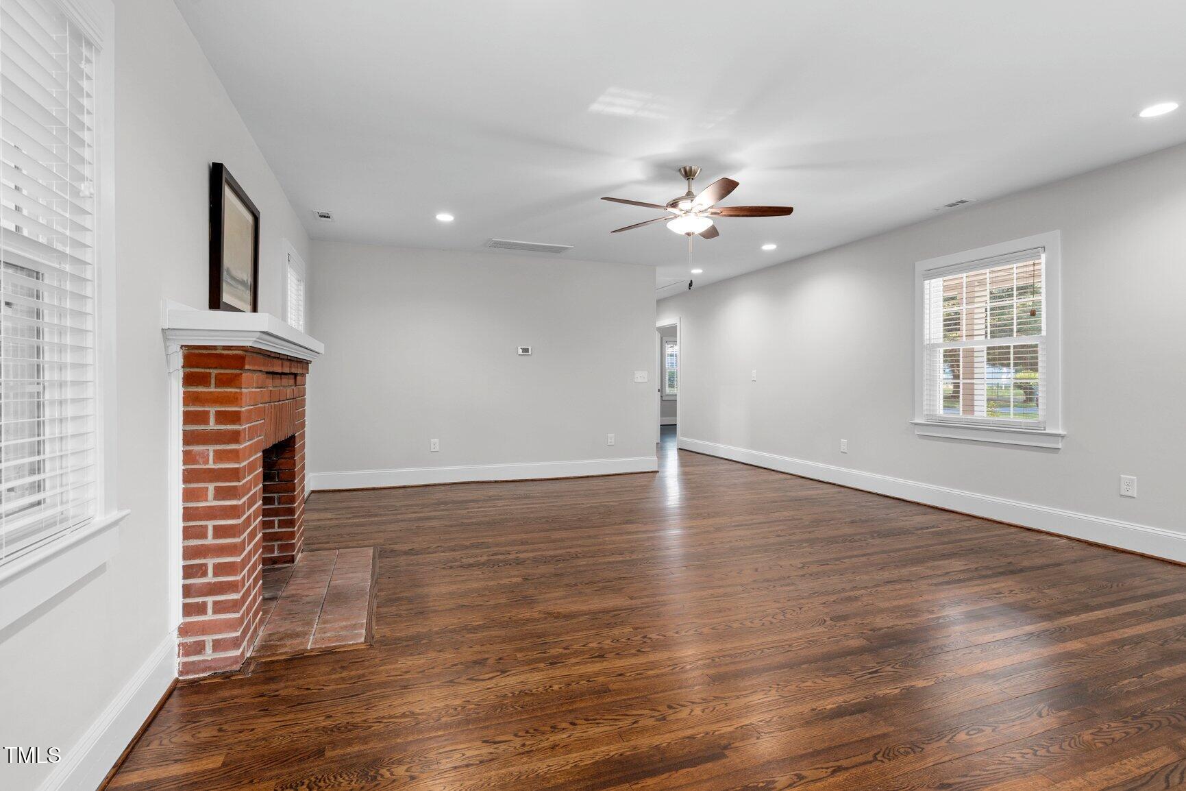 419 West Burnette Avenue Enfield, NC 27823 - Photo 6 of 23 an empty room with wooden floor and windows