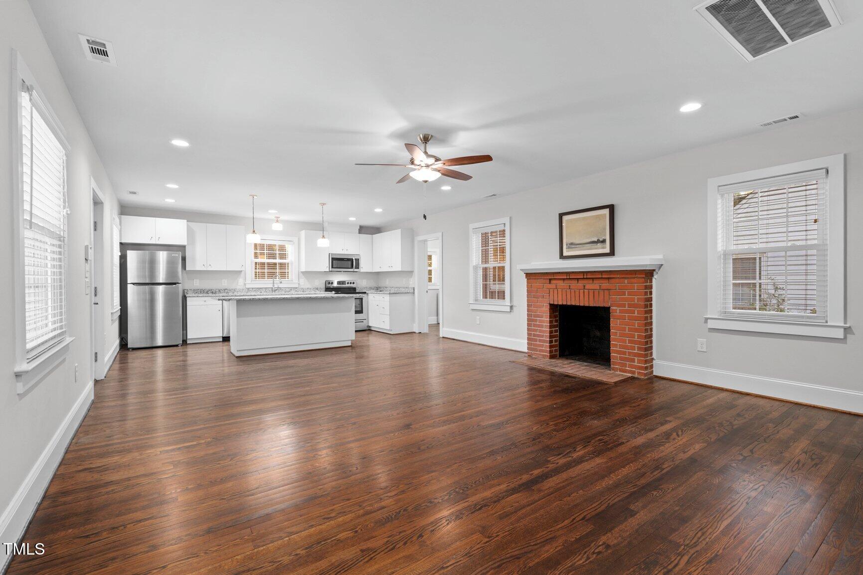 419 West Burnette Avenue Enfield, NC 27823 - Photo 23 of 23 a view of an empty room with wooden floor and a kitchen