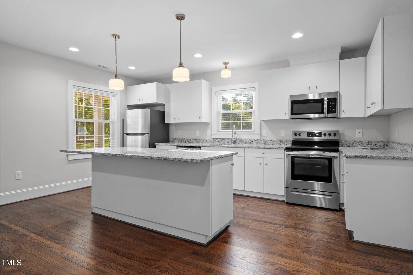 419 West Burnette Avenue Enfield, NC 27823 - Photo 8 of 23 a kitchen with granite countertop a stove a sink and a wooden floor