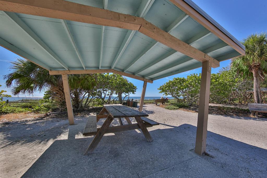 1400 Beach Road, Unit 3 Englewood, FL 34223 - Photo 44 of 60 a view of a patio with table and chairs under an umbrella with a patio