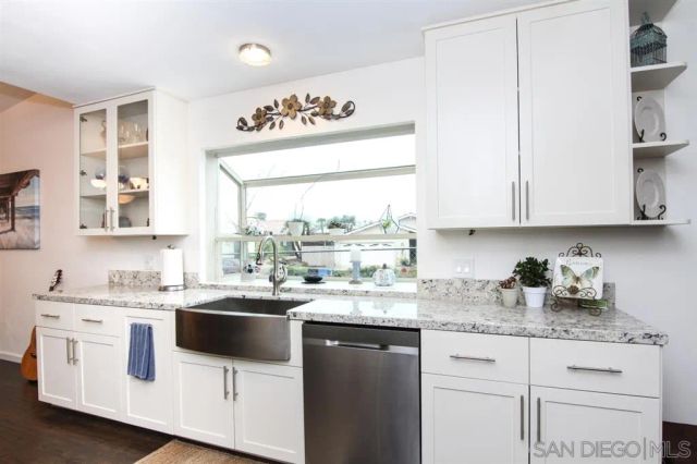 a kitchen with stainless steel appliances white cabinets sink and window