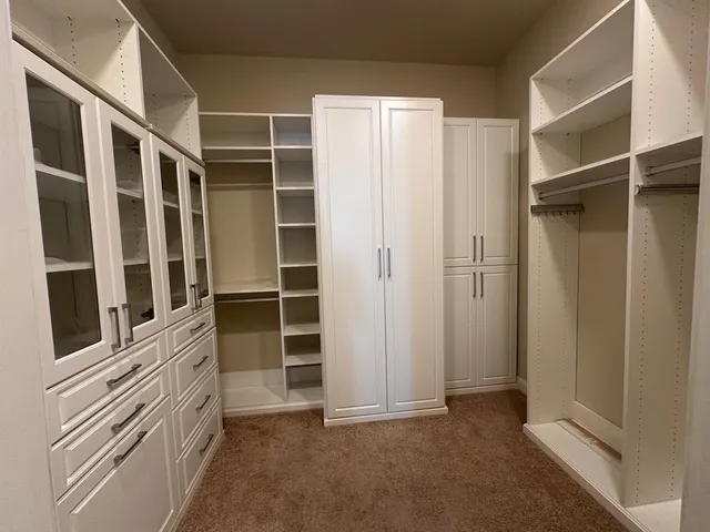 a view of walk in closet with empty racks