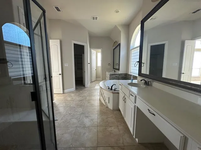 a large bathroom with a double vanity sink a mirror and a shower