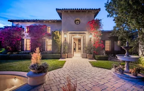 a front view of a house with a yard and a fountain