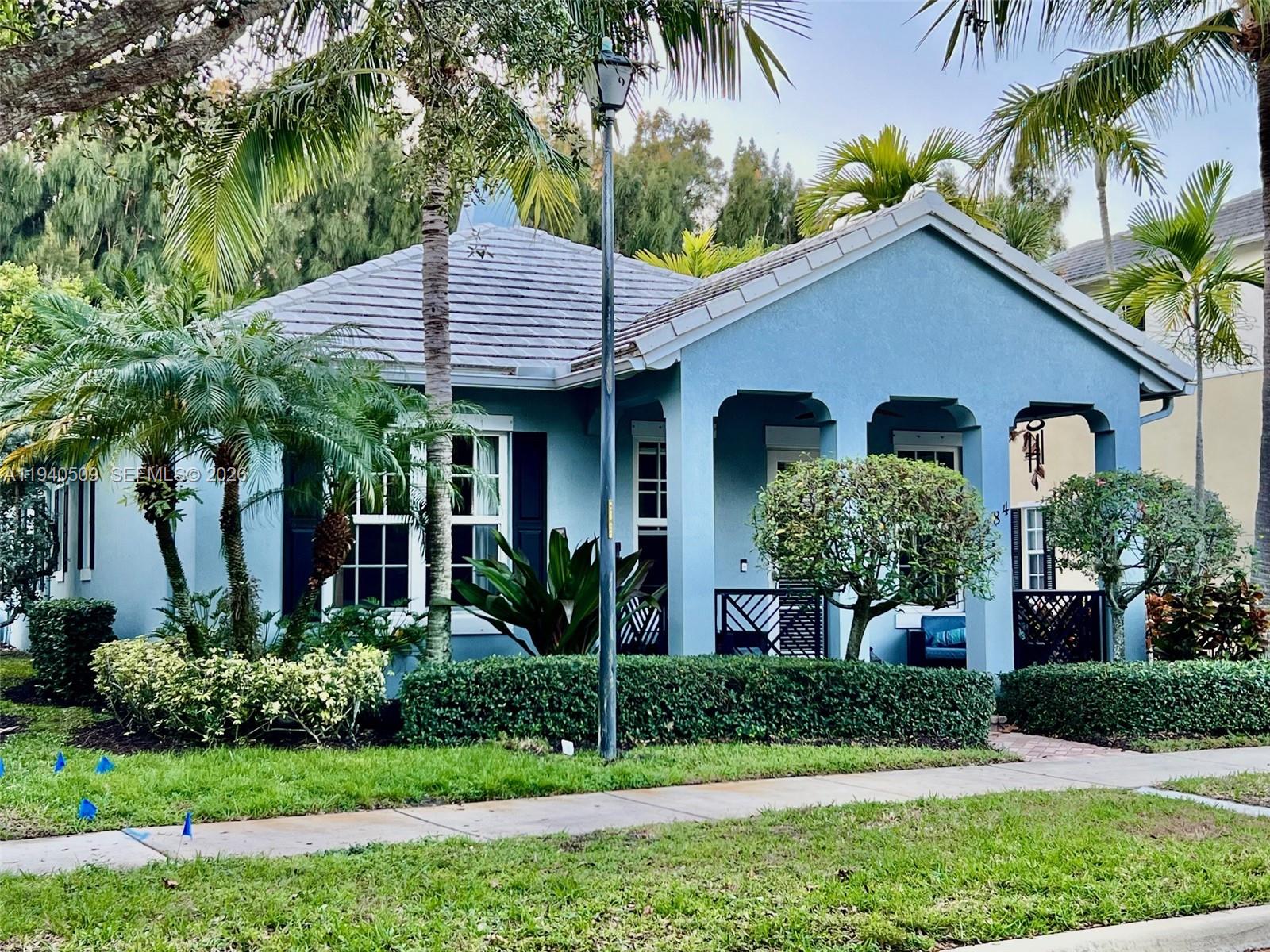 a view of a house with a yard plants and palm trees