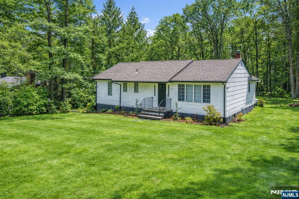 a backyard of a house with wooden fence and large trees