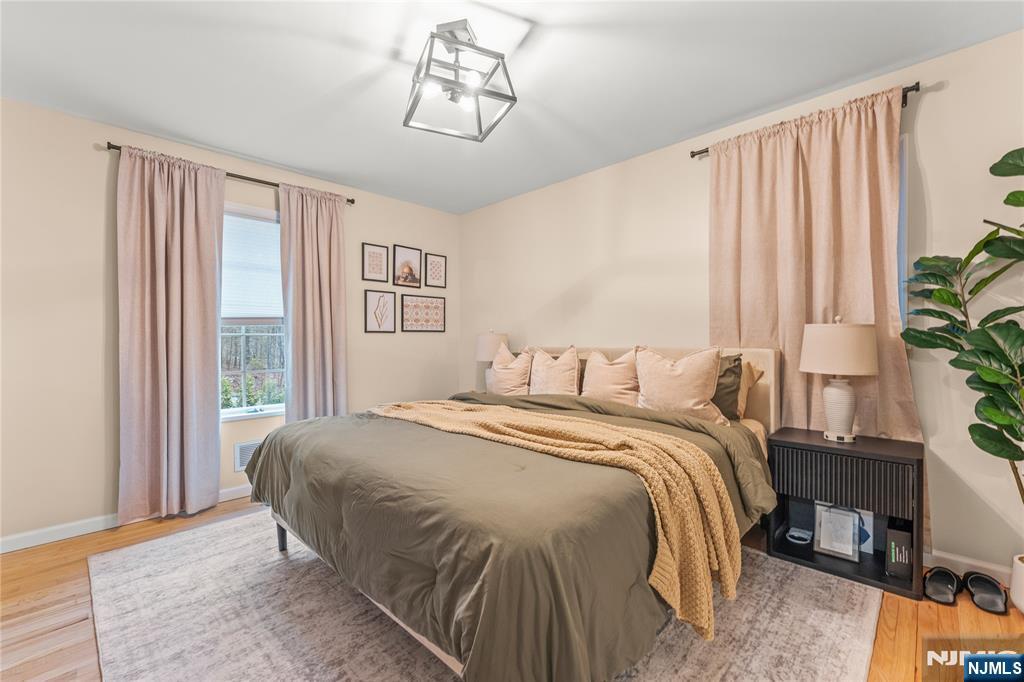 163 La Rue Road West Milford, NJ 07435 - Photo 19 of 28 a bedroom with a large bed and a chandelier