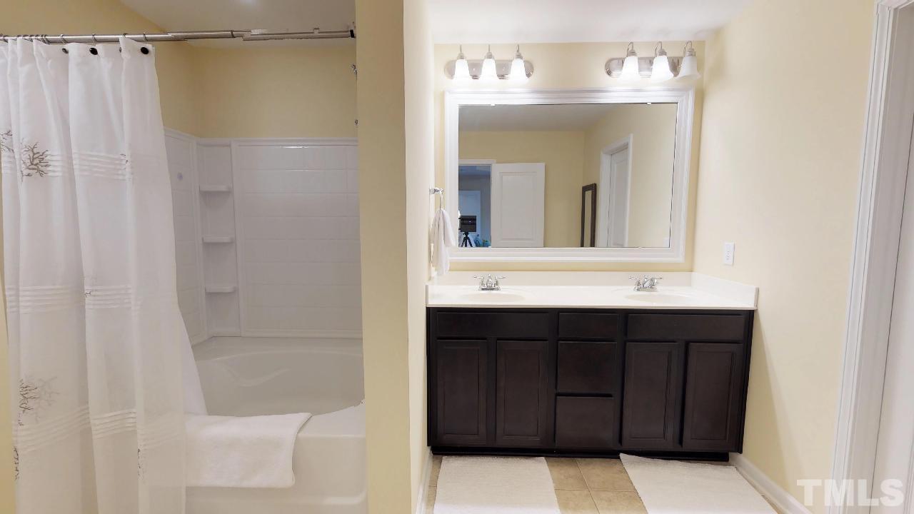 1023 Ileagnes Road Raleigh, NC 27603 - Photo 16 of 25 a bathroom with a sink vanity and a mirror