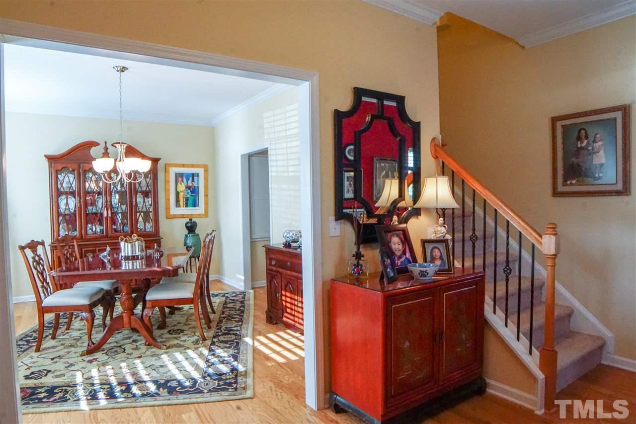 1023 Ileagnes Road Raleigh, NC 27603 - Photo 7 of 25 a view of a hallway with wooden floor and a chandelier