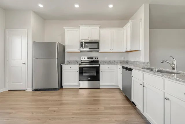 a kitchen with a refrigerator cabinets and wooden floor