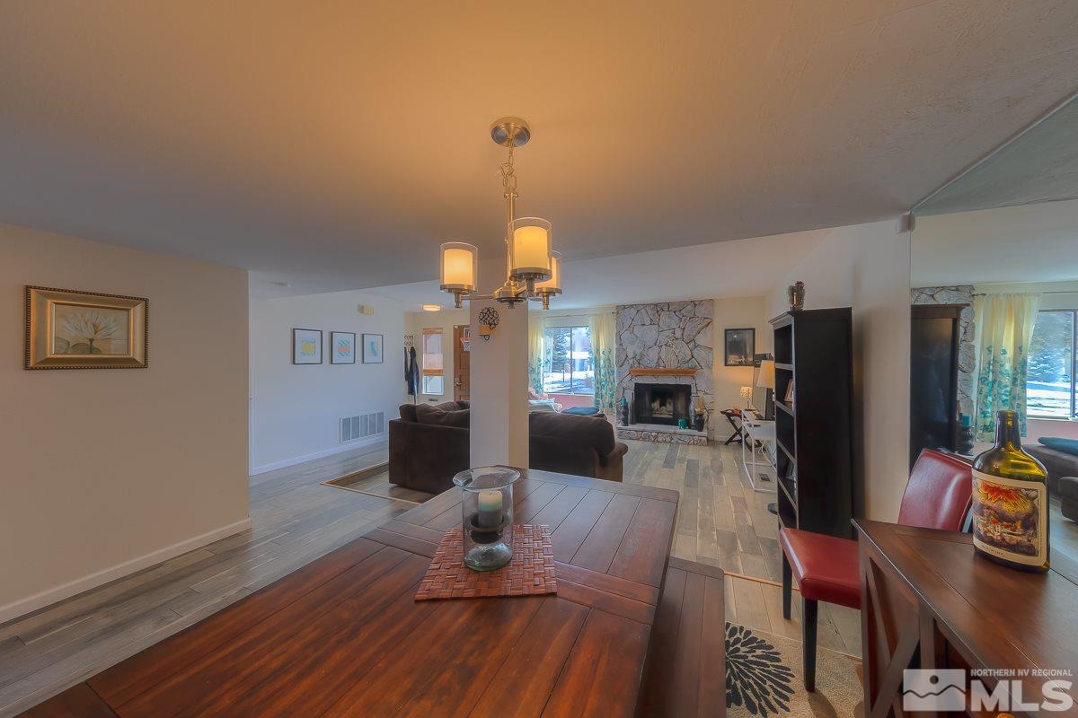 1499 Foster Drive Reno, NV 89509 - Photo 14 of 24 a living room with furniture a fireplace and a chandelier