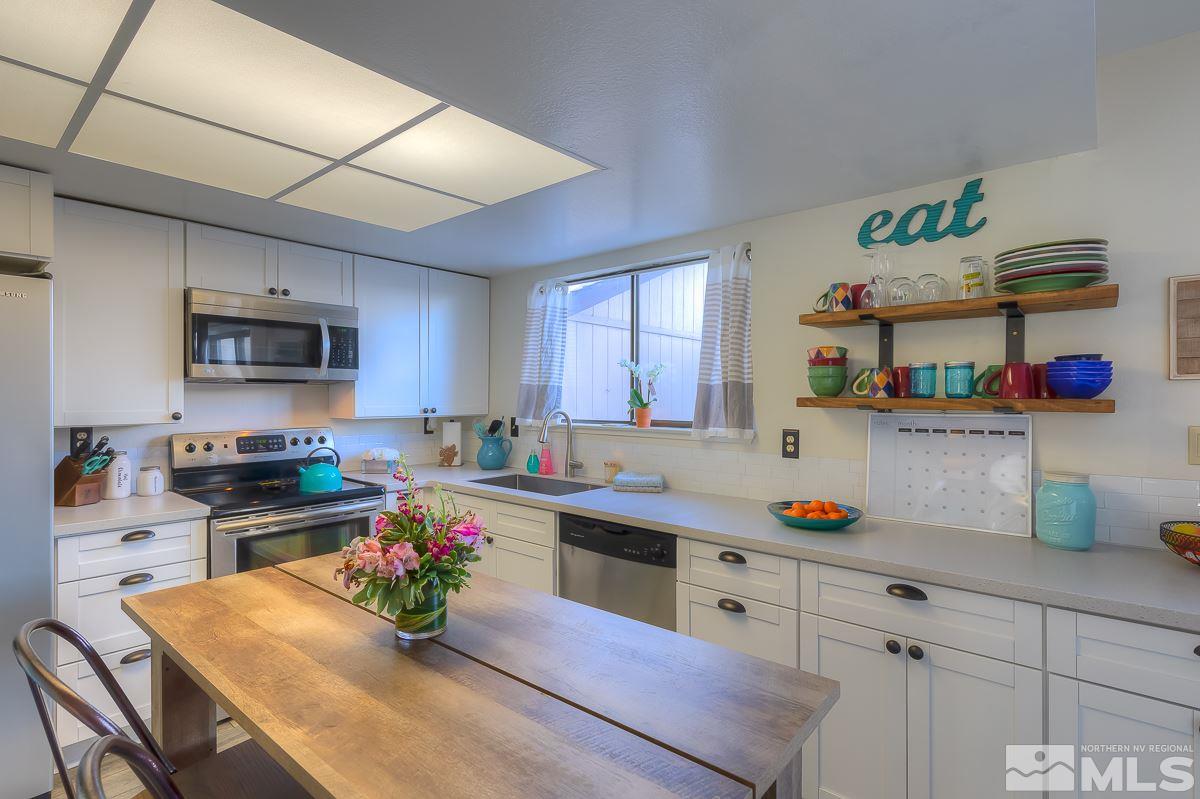 1499 Foster Drive Reno, NV 89509 - Photo 6 of 24 a kitchen with granite countertop lots of clutter and stainless steel appliances
