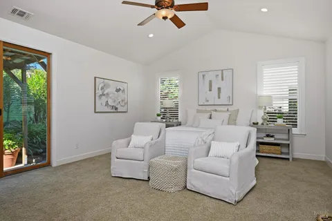 a living room with furniture a ceiling fan and a flat screen tv