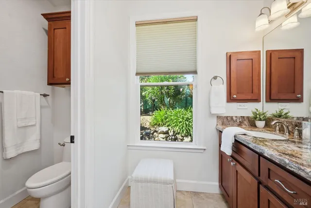 a view of a patio with table and chairs potted plants and floor to ceiling window
