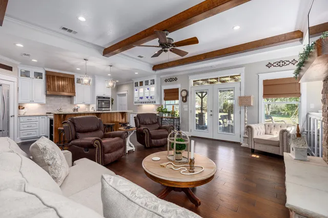 a living room with furniture kitchen view and a large window