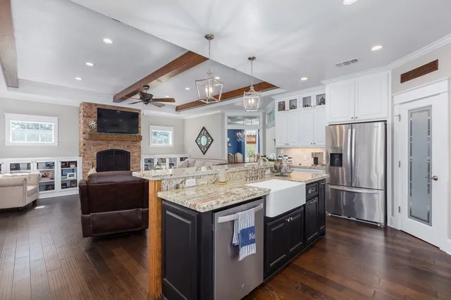 a living room with stainless steel appliances kitchen island granite countertop a stove and a refrigerator