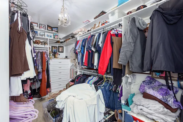 a view of walk in closet with clothes