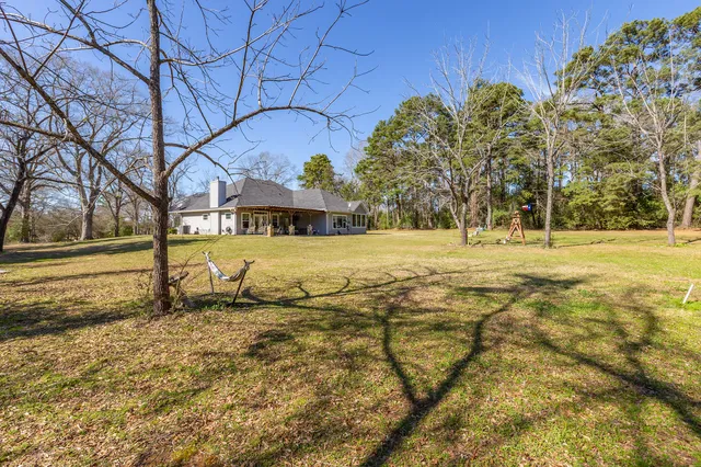 a view of a house with swimming pool next to a yard