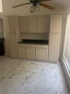 a view of an empty room with wooden floor fireplace and a window