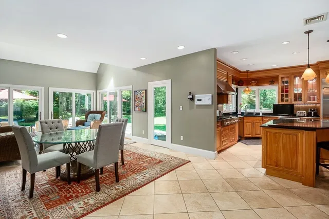 a view of a dining room and livingroom with furniture large windows