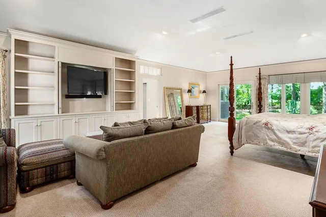 a living room with furniture a flat screen tv and a large window